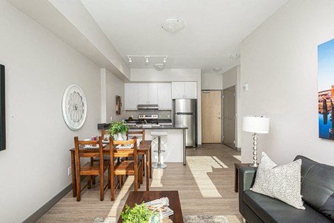 A modern kitchen with a dining table and a couch.